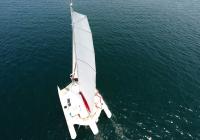 flatten main sail on mast of sailing trimaran yacht